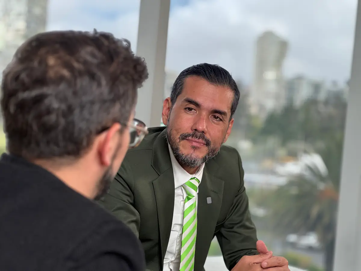 Hipólito Carrera conversa con una persona durante una reunión de trabajo